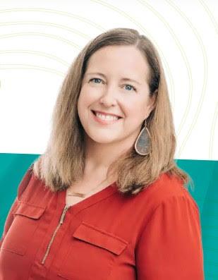 A woman with shoulder-length brown hair wears a bright red top with zipper & pocket details smiles.